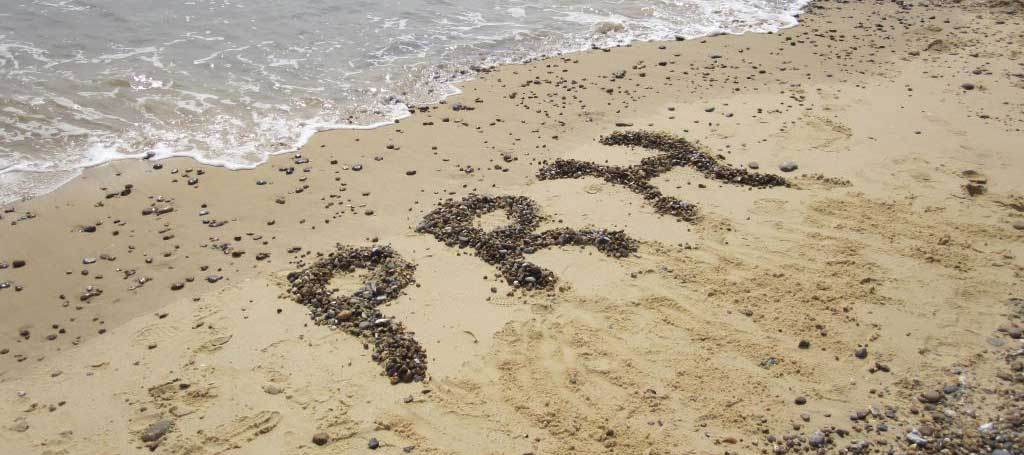 PRH written with pebbles on a beach